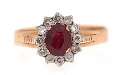 SOLD. A ruby and diamond ring set with an oval-cut ruby encircled by numerous brilliant-cut...