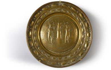 A set of two repoussé brass quest or offering dishes, one decorated with a rosette of twisted gadroons, the other depicting Adam and Eve in a frieze of stylised motifs.