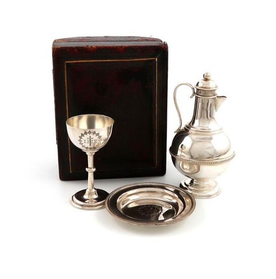 A three-piece Victorian silver travelling communion set, by The Barker Brothers, Birmingham 1887, comprising: a small flagon, chalice and paten, all pieces engraved with a cross and IHS, in a fitted case, height of chalice 7.2cm, approx. weight 4.7oz...