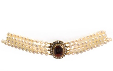 A uniform four row cultured pearl necklace with a garnet set clasp