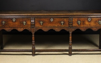 An 18th Century Dresser Base. The top having a moulded edge over three frieze drawers fitted with el