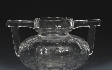 An Aesthetic Movement Stevens and Williams rock crystal glass flower vase probably cut by John Orchard, ovoid with collar rim and applied angled handles, the faceted body engraved with Japoniste prunus sprays unsigned, 10.5cm. high, 18.5cm. wide
