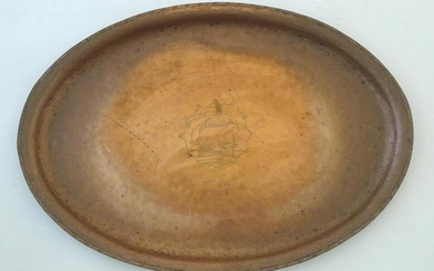 An Arts & Crafts copper tray of oval form with ship