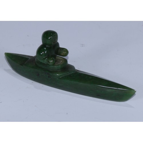An Inuit nephrite jade carving, of a figure in a canoe, 13cm...