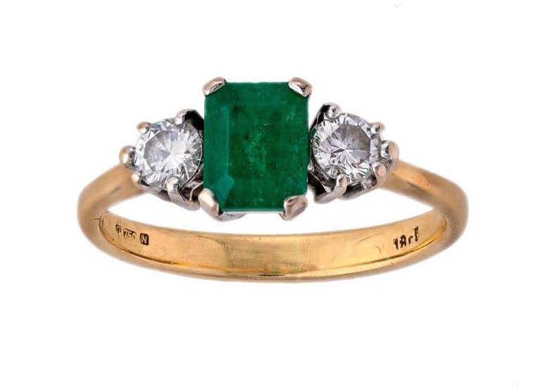 An emerald and diamond ring, centring on a step-cut emerald set between a pair of brilliant-cut diamonds, ring size K