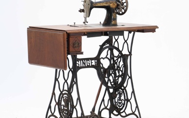Antique Singer sewing machine with accompanying table, frame and foot pedal made of black lacquered cast iron. 20th century first third