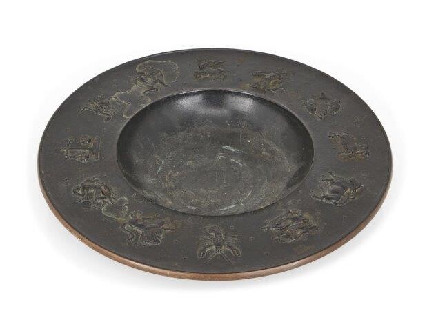 Fritz Nuss, German, 1907-1999, a cast bronze 'Zodiac' bowl, 1946, the wide rimmed bowl with original patina and modelled with zodiac signs to the rim, signed 'Nuss 46', 26.5cm diameter