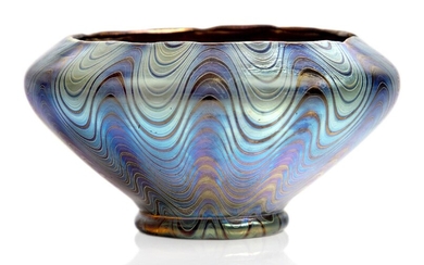 Loetz (Austrian), an iridescent Rubin Phaenomen glass bowl with inverted rim, c.1898, PG 6893, ground out pontil, The red glass body decorated with silver and blue iridescent undulating threads and bands, 6.7 cm high, 12.7 cm wide, Property from a...