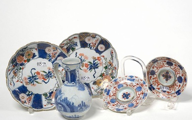 Lot de cinq porcelaines du Japon comprenant: une verseuse bleue et blanche d’Arita décorée d’un "Paysage animé". Epoque: XVIIème. On y joint une paire d’assiettes chantournées et deux soucoupes polychromes à décor végétal et floral. Epoque: XVIIIème...