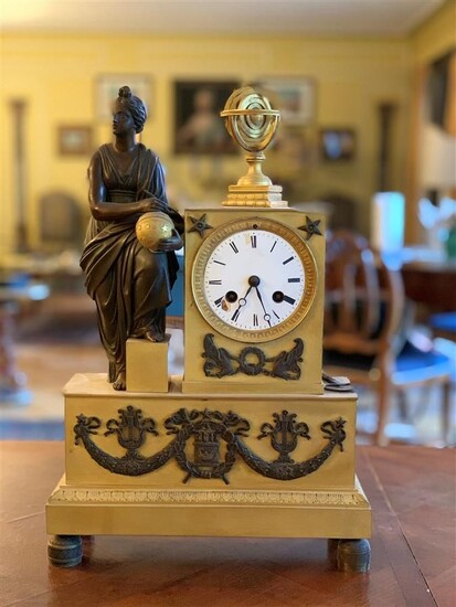 Pendule en bronze à patine brune et dorée à décor d'une figure à l'Antique symbolisant...