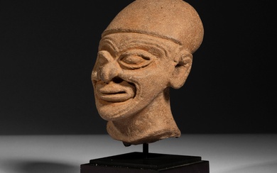 Une belle tête souriante d’un homme ridé, fragment d’une ancienne statuette. Culture dite Tumaco-La Tolita,...