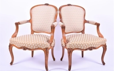 A pair of French Louis XV style fauteuils with upholstered backings, arm rests and seats, in carved walnut frames with scrolls...