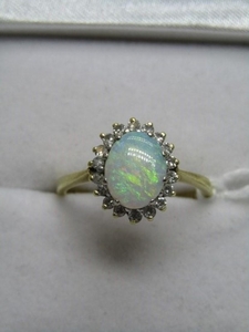 18ct YELLOW GOLD OPAL & DIAMOND RING; Central oval cut opal ...