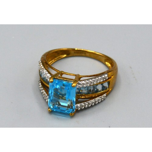 A 9ct. Gold Dress Ring set with a central rectangular blue s...