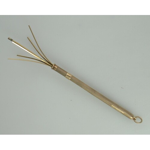 A 9ct gold cocktail stirrer. With engine turned decoration ...