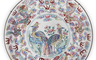 A Chinese Canton enamel 'dragon and phoenix' dish, Daoguang period, painted to the central reserve with phoenixes inside a border of dragons amid cloud swirls, 30.5cm diameter 清道光 廣東銅胎畫琺瑯龍鳳紋盤