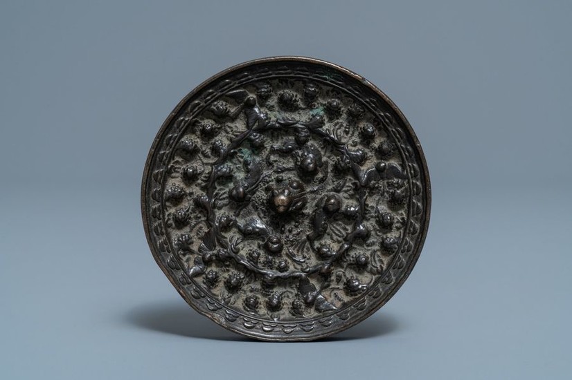 A Chinese bronze mirror with relief design, Tang...