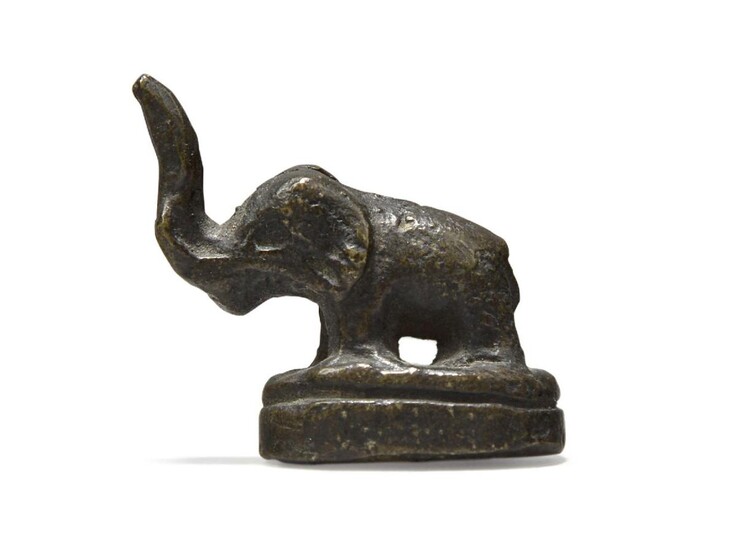 A Chinese bronze small elephant, Ming dynasty, 17th century, cast standing four square on an oval base, 3cm long Provenance: With invoice from Glade Antiques, 8th October 2002