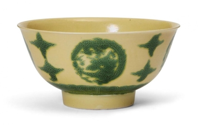 A Chinese porcelain yellow-ground green-enamelled 'dragon medallion' bowl, Kangxi mark and of the period, incised and enamelled in green to the exterior with four roundels of coiled dragons pursuing a flaming pearl, interspersed with cloud swirls...