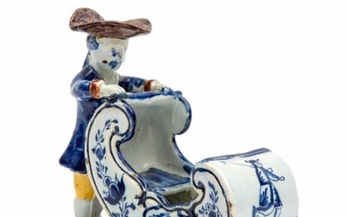 A Delft polychrome pottery figure of a man on ice skates pushing a sleigh
