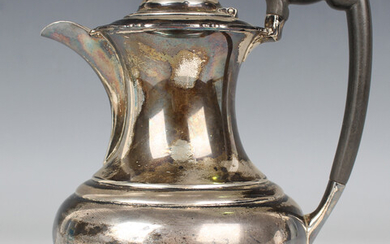 A George V silver hot water pot of baluster form with scroll feet, Sheffield 1922 by Atkin Brothers
