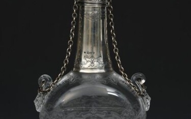 A Thomas Webb crystal glass pilgrim flask with silver mounts by William Hutton & Sons Edward Hutton, the flattened disc body cut with panels of exotic foliage, applied mask handles, on domed silver foot, the silver neck and cover cast and engraved...
