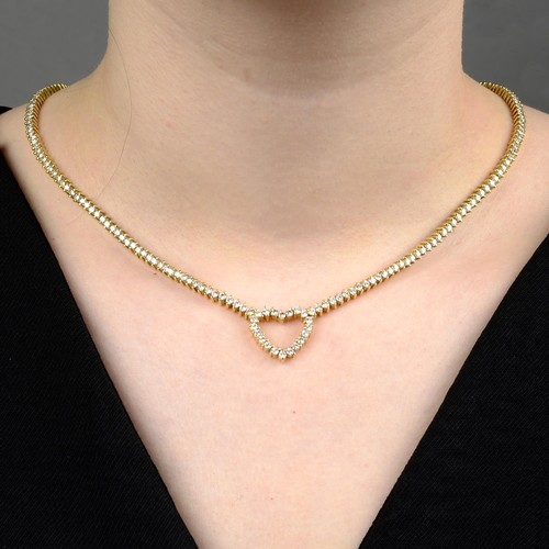 A brilliant-cut diamond line heart necklace. Estimated total...