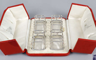 A cased set of four small George V silver toast racks.