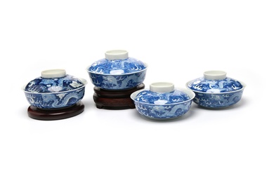 A group of blue and white porcelain covered bowls painted with dragons writhing amidst clouds