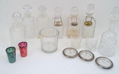 A group of cut crystal and glass decanters, 20th century, of which six are of rectangular form with decorative geometric patterns to the body, with five globular stoppers and one cuboid stopper; and one of tapering cylindrical form with an ovoid...
