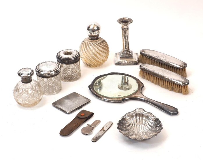 A group of silver items comprising: a Victorian silver bonbon dish designed as a scallop shell, Sheffield, c.1899, James Deakin & Sons; a silver cigarette case, Birmingham, c.1917, Edwards & Sons; two silver mounted cut glass vanity jars, one...