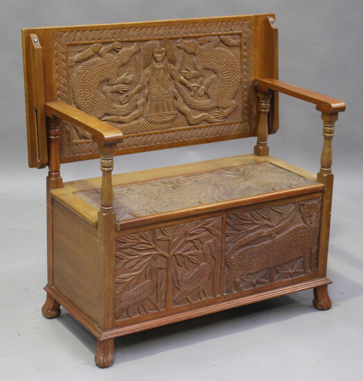 A late 20th century African carved hardwood monk's bench, the hinged box seat and front carved