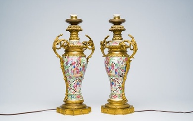 A pair of Chinese Canton famille rose vases and covers with palace scenes and floral design mounted