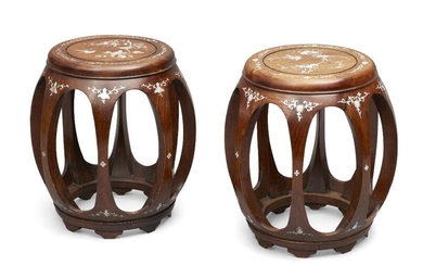 A pair of Chinese mother of pearl inlaid wood barrel stools, late Qing dynasty, the top with a recessed circle enclosing a mother of pearl inlaid panel of phoenixes among flowers, supported by eight outward curved legs, 45cm high. (2) 晚清 花梨木雕嵌螺鈿鼓凳一對