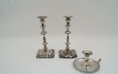 A pair of Edwardian silver candlesticks, Birmingham, 1900 and 1902, I S Greenberg & Co, damaged, with knopped stems on stepped foliate decorated bases, filled, 23cm high, together with a silver chamber stick, London, 1775, probably John Arnell...