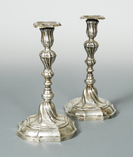 A pair of German metalwares cast candlesticks, and another pair