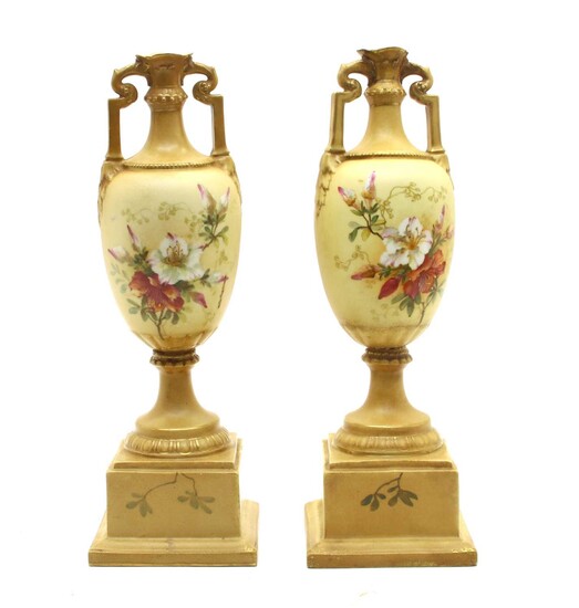 A pair of Vienna porcelain twin-handled urns on stands