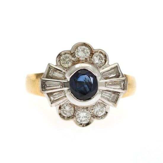 A sapphire and diamond ring set with an oval-cut sapphire encircled by six brilliant-cut and six trapez-cut diamonds, mounted in 18k gold and white gold.