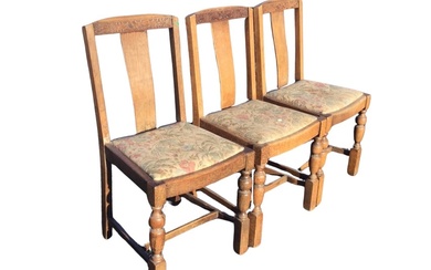 A set of three 30s oak dining chairs with carved...