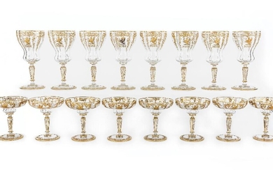 A suite of Continental cut-glass hosting table wares, in the style of Moser, 20th century, of quatrefoil design, each with elaborate scrolling raised gilt decoration to the rims and enamel griffins with initials MHB, comprising: eight wine glasses...