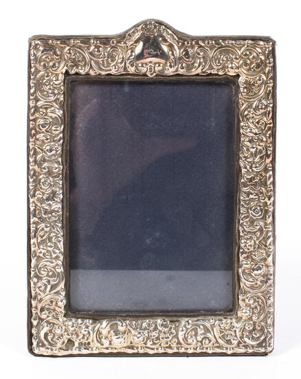 A vintage silver mounted picture frame, the mount decorated with embossed foliate motifs