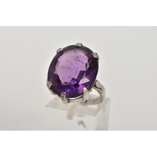 AN 18CT WHITE GOLD AMETHYST RING, the oval amethyst within a...