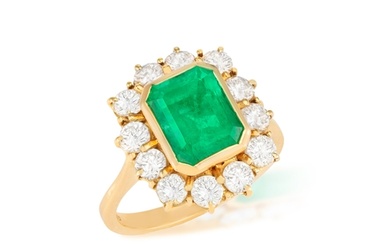 AN EMERALD AND DIAMOND CLUSTER RING The rectangular-cut eme...