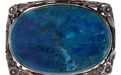 An Australian Arts & Crafts silver and hardstone brooch, by Wager, designed as an oval blue stained hardstone panel, with naturalistic foliate surround, the reverse with maker's plaque Wager for Rhoda Wager, c.1930, dimensions 5.2cm x 3.7cm
