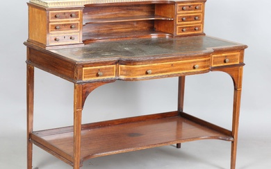 An Edwardian mahogany and satinwood crossbanded writing table, the frieze back fitted with drawers