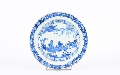 Chine, XVIIIe siècle. Plat en porcelaine bleu-blanc, à décor de deux lettrés dans un paysage,...