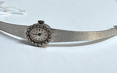 FLAMOR MONTRE bracelet de dame en or gris, lunette entouré de pierres blanches, poids 28.7g...