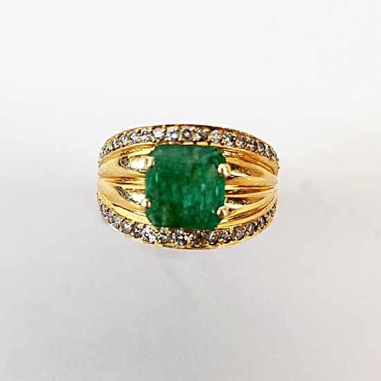 Gold ring 750 ‰, set with a step-cut emerald between...