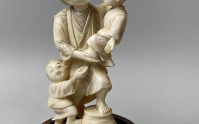 JAPON, c.1930-1940. Okimono en ivoire sculpté représentant un homme portant un enfant dans ses bras,...