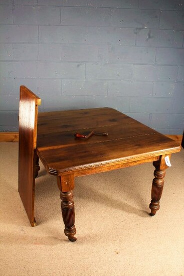 Late Victorian extending dining table, with chamfered corners, raised on fluted legs and castors